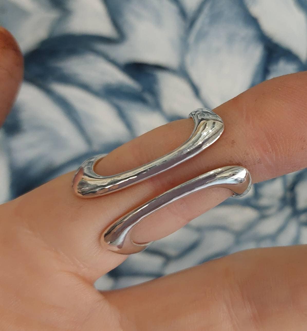 Side view of a butterfly finger splint ring providing alignment and joint support
