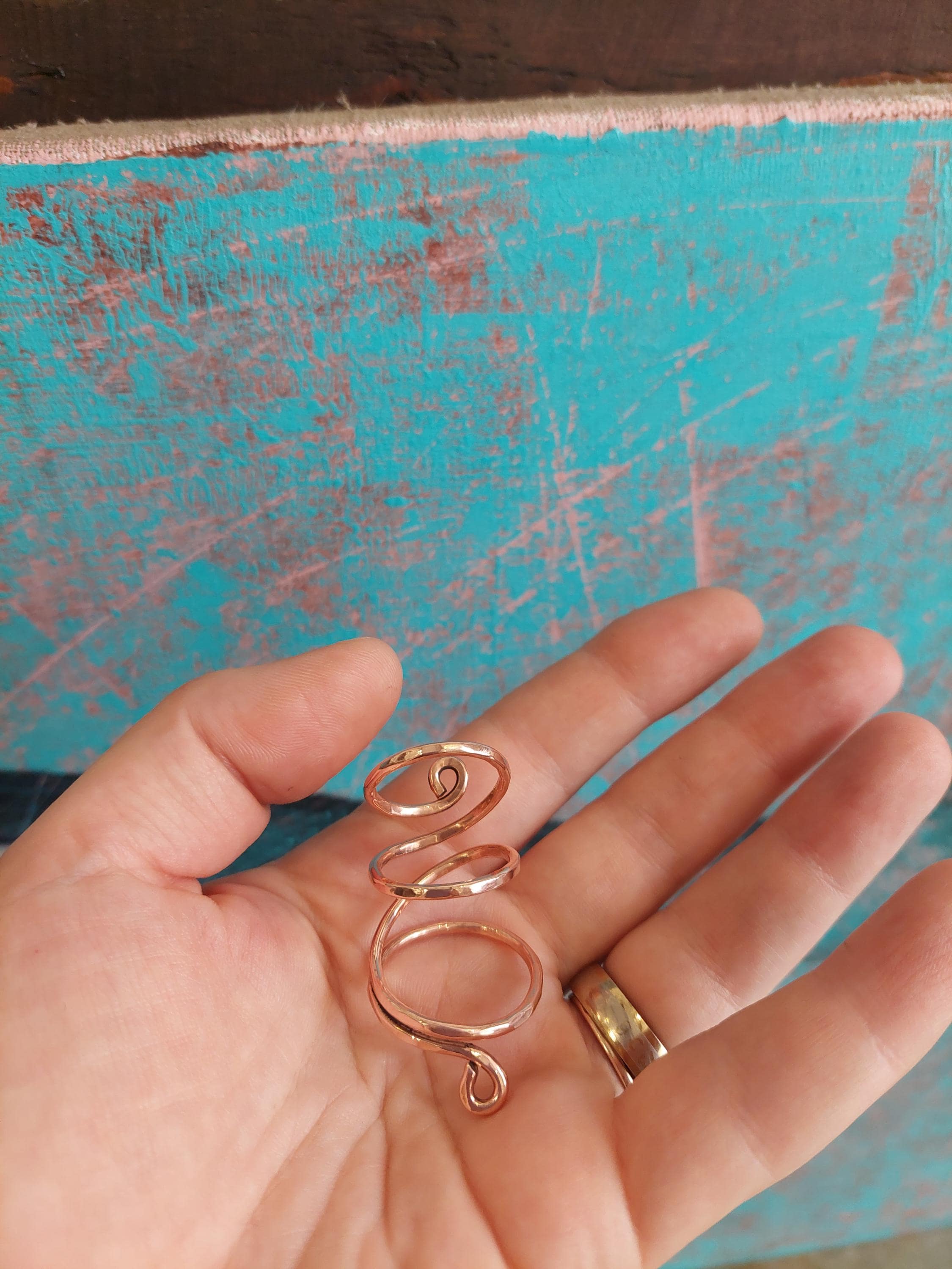 Close-up of handmade copper thumb splint ring with polished finish
