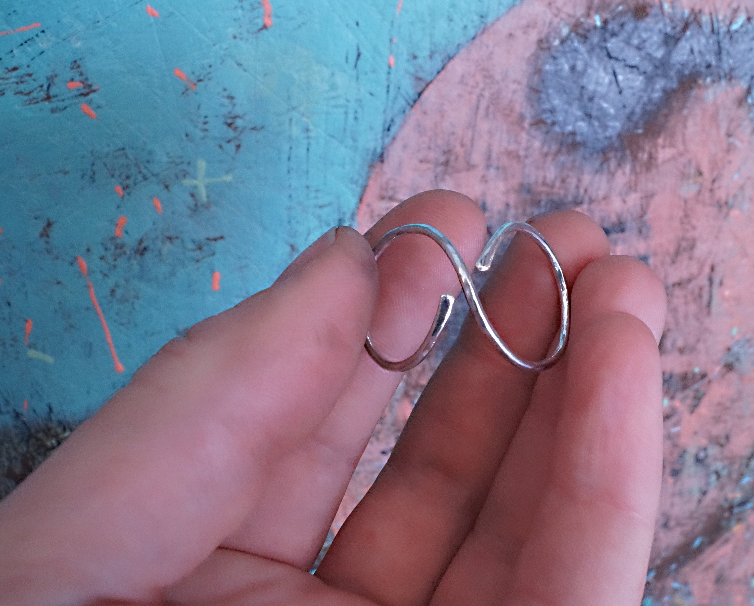 Close-up of a hammered textured sterling silver finger splint ring with adjustable design