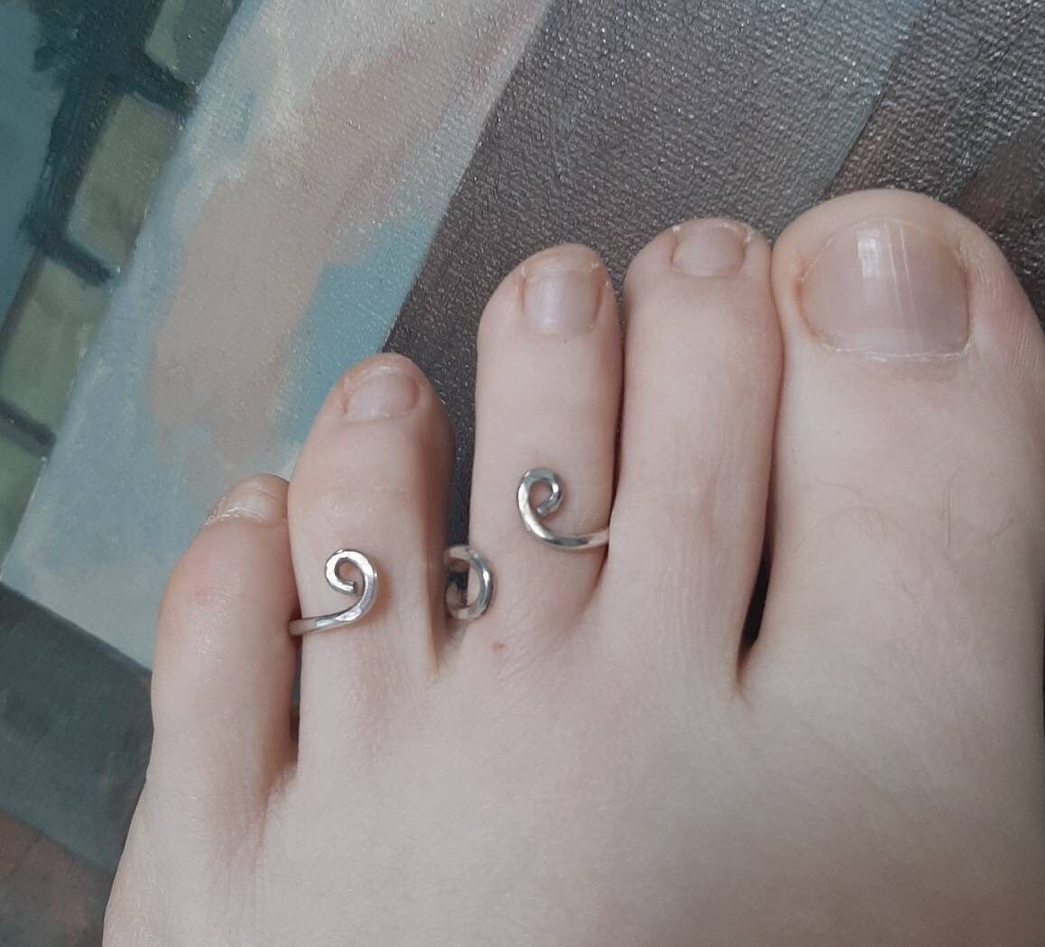 Handcrafted sterling silver toe alignment splint with two connected rings for joint support