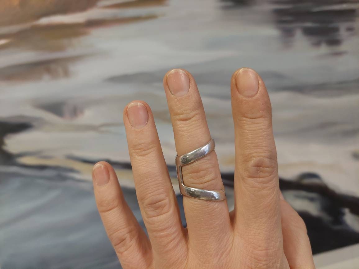Decorative bronze ring splint for lateral deviation finger support and arthritis finger joint protection.