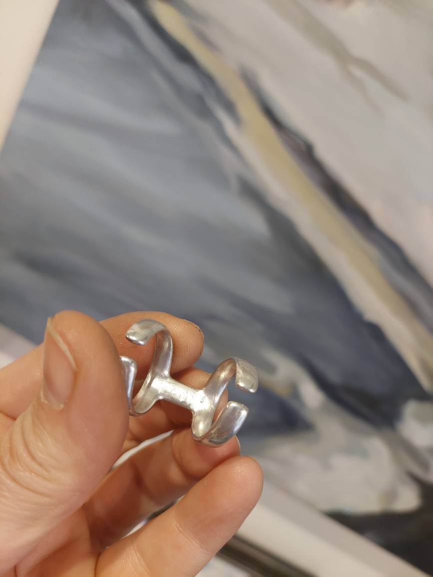 Handmade bronze splint ring worn on finger to support joint alignment.
