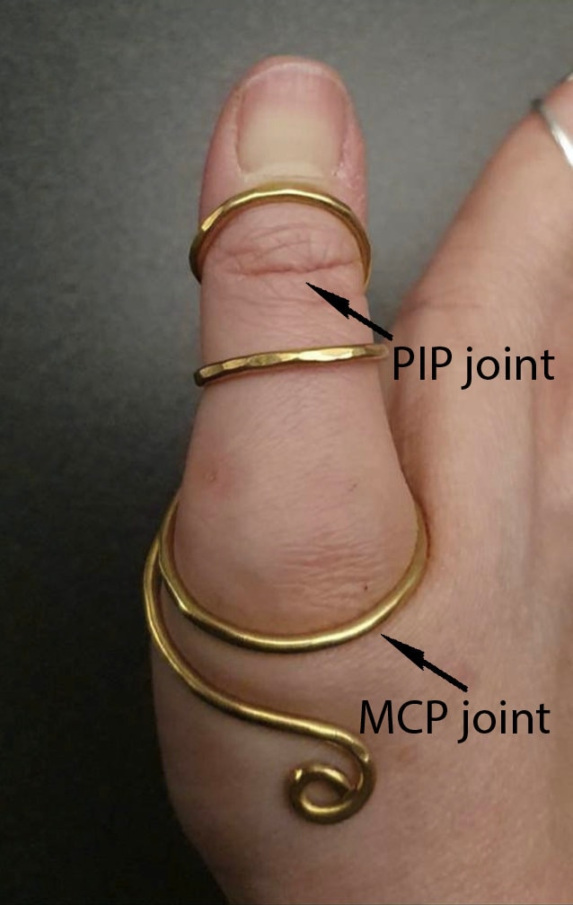 Yellow brass thumb support ring designed to stabilize the  joint and improve alignment